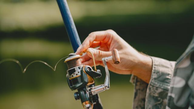 A man fishing on a lake. Guy in a uniform.