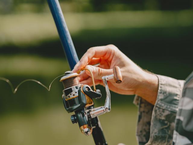 A man fishing on a lake. Guy in a uniform.