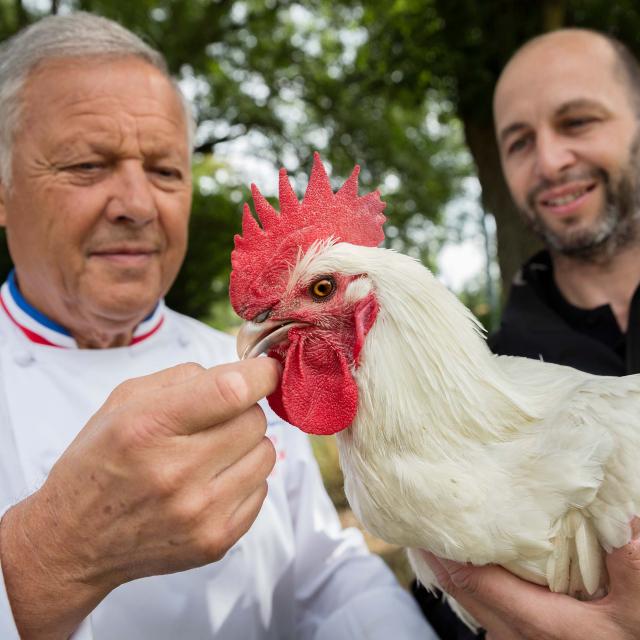 Le chef Georges Blanc et l'éleveur Cyril Degulaire autour d'un poulet de Bresse AOC. Infos auprès de votre office de tourisme Bourg en bresse destinations.