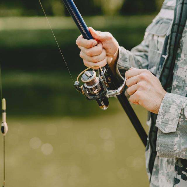 A man fishing on a lake. Guy in a uniform.