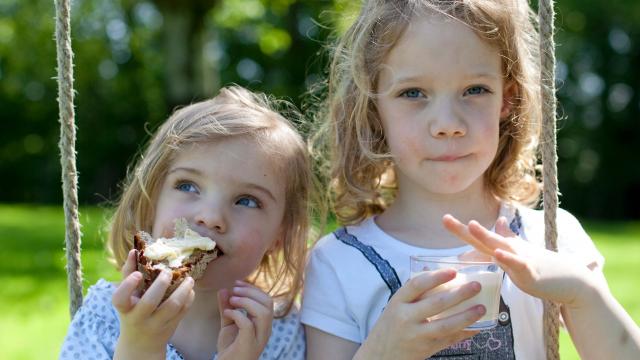 Deux petites filles qui grignotent une tartine de pain avec du beurre de Bresse AOP