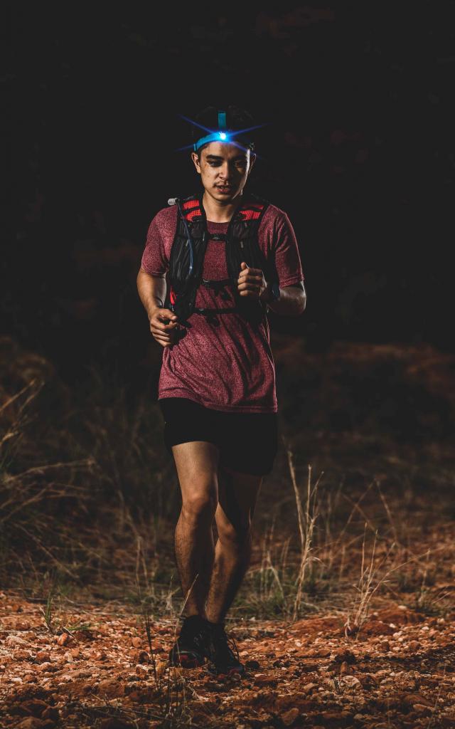 trail runner running on the rocky road in the night